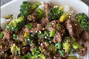 Beef with broccoli and rice on a white plate.