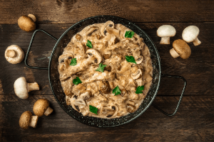Creamy noodle and beef casserole cooked in a deep pan with mushrooms.