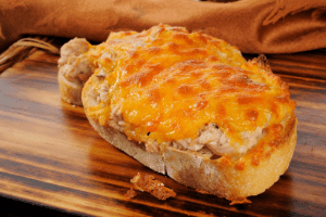 Cheese melted on top of cooked tuna with mayo on bread, baked. 
