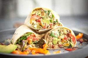 3 White tortilla wraps filled with tuna and other veggies. 