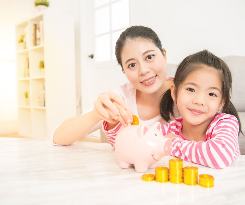 Mom and daughter smiling putting money into a piggy bank for savings.