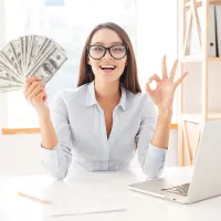Woman holding money and smiling.