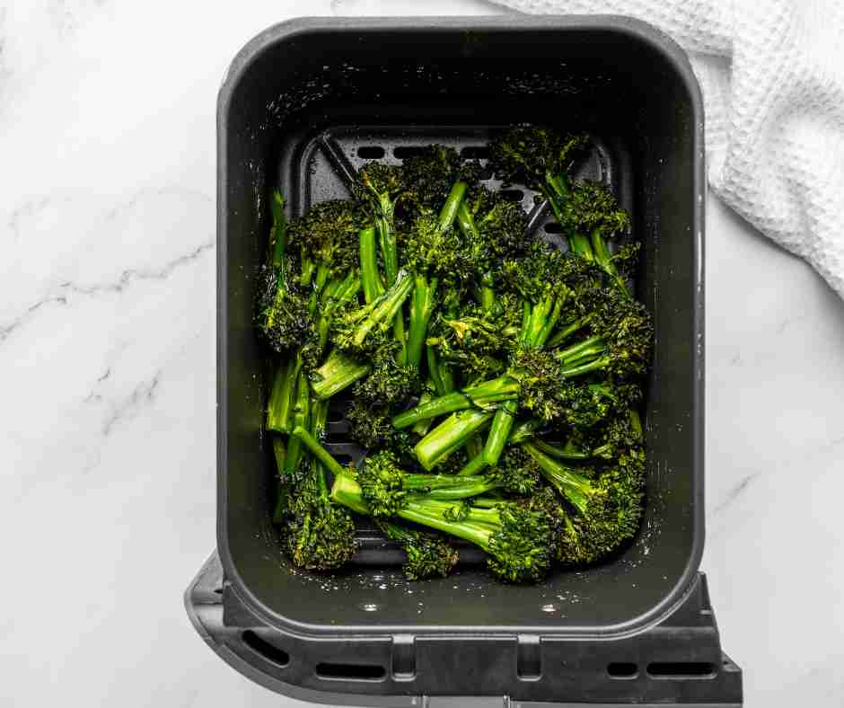 Seasoned cooked broccoli in the air fryer.